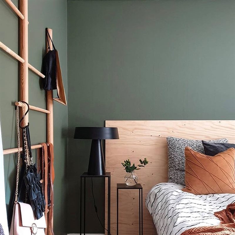 Sovrum målat med gröna väggar och behagliga textilier